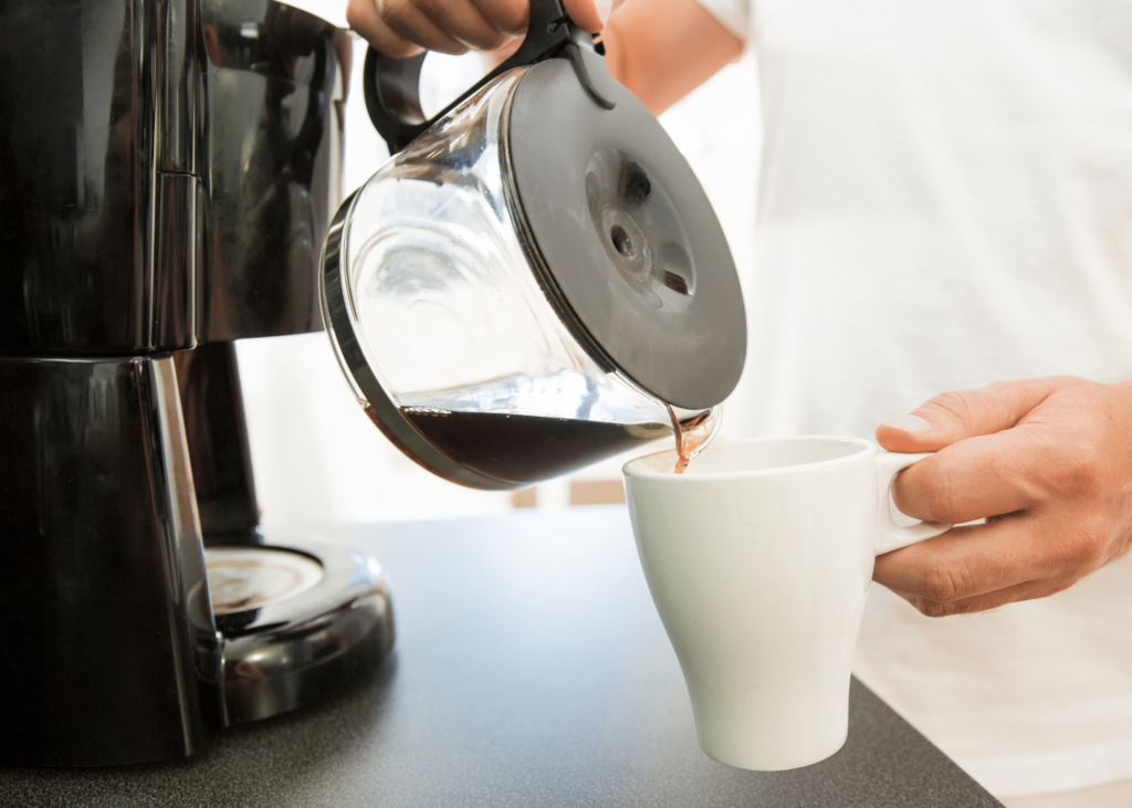 best 4 cup coffee maker, photo of a person pouring coffee from the pot into a white mug