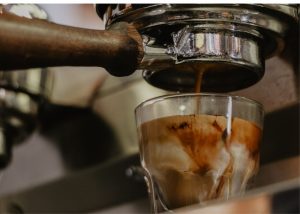 breville infuser, photo of a shot of espresso pouring into a clear little glass