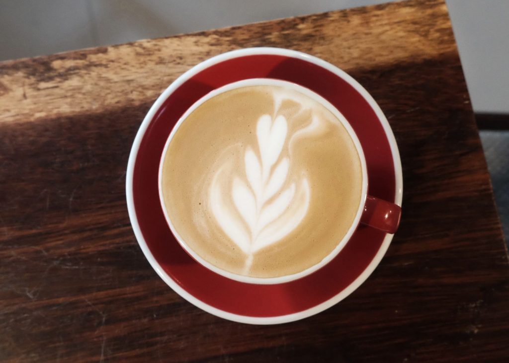 red eye coffee, photo of latte in a red mug on a wooden table